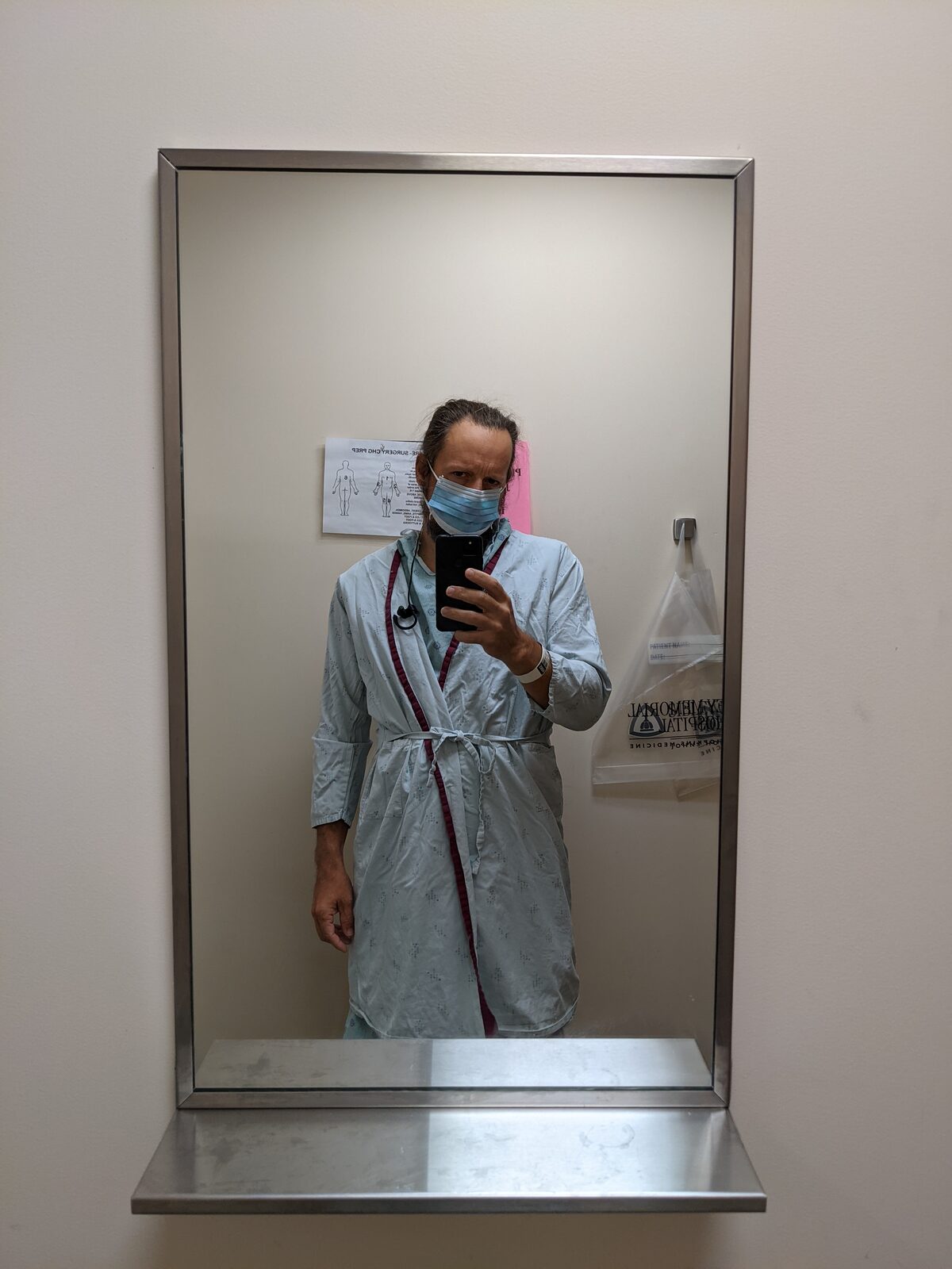 Standing in a hospital gown before surgery