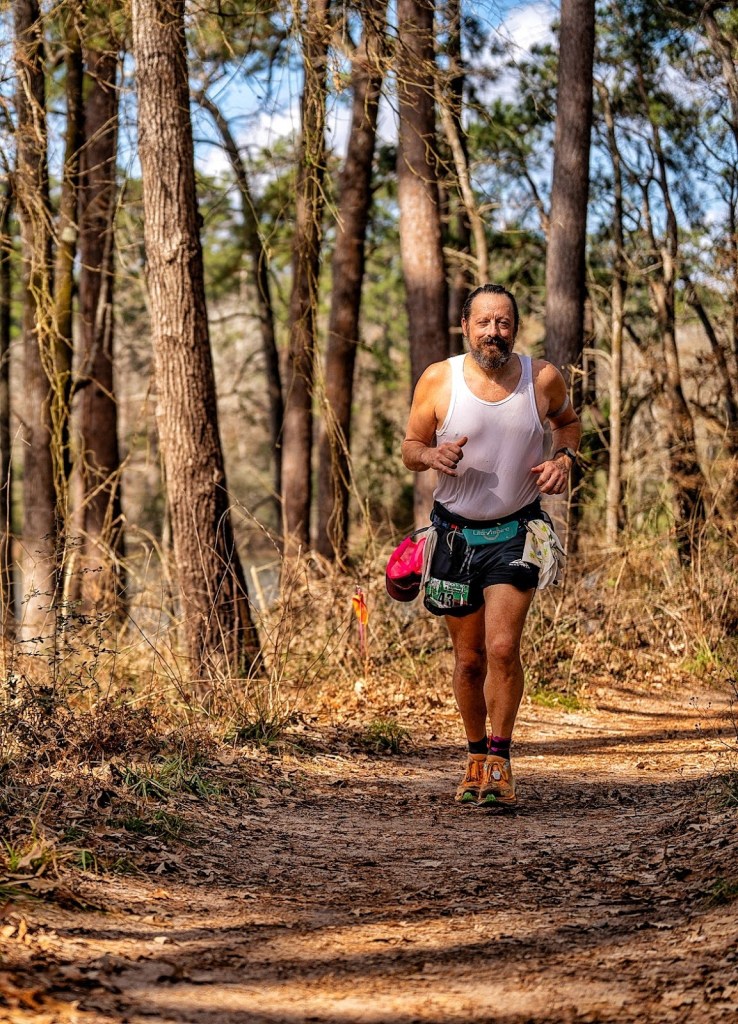 Trail runner, running through the woods.